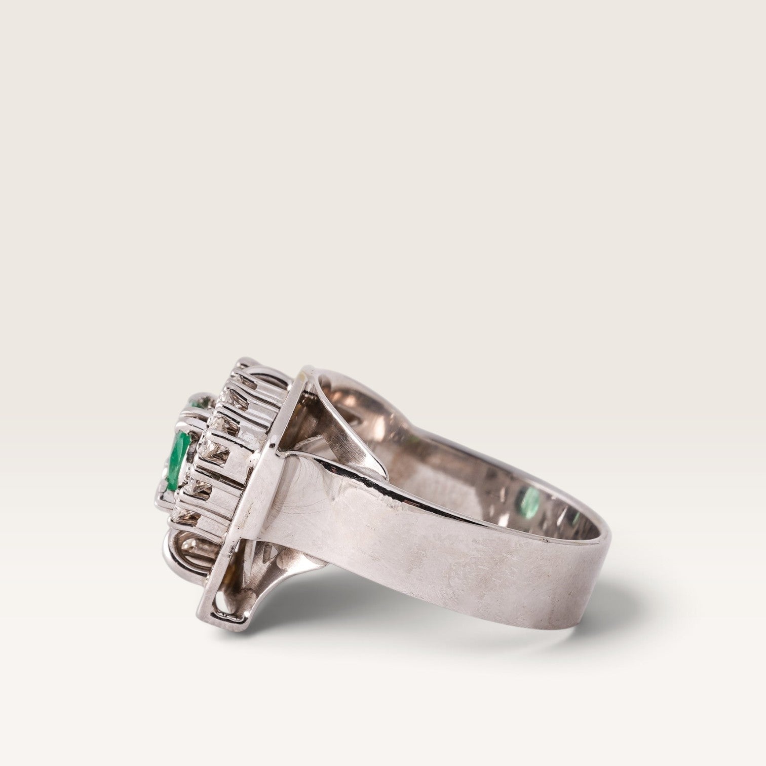 Menina Amsterdam 14K white gold statement ring featuring a central emerald surrounded by brilliant-cut diamonds.