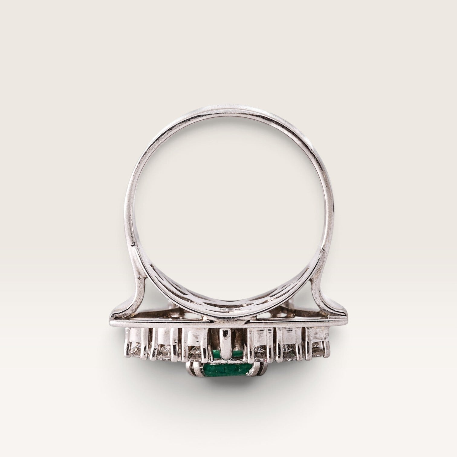 Menina Amsterdam Veyla 14K white gold statement ring with a central emerald and diamond halo, side view.